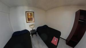 a room with two beds and a tv in it at JESAVI Leones in Monterrey
