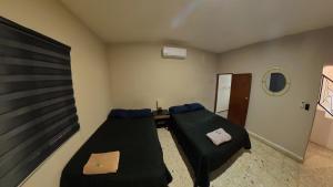 a room with two beds and a mirror in it at JESAVI Leones in Monterrey