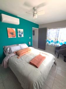 a bedroom with a large bed with a green wall at Turquesa by the Sea, Elevated Ocean View Retreat in San Carlos