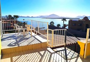 a balcony with two chairs and a view of the water at Turquesa by the Sea, Elevated Ocean View Retreat in San Carlos