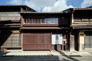 an old building with a red door and windows at Obama Machiya Stay in Obama