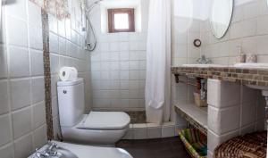 a white bathroom with a toilet and a sink at Casa Rural Zambra in Priego de Córdoba