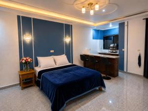 a bedroom with a bed and a desk and a television at Résidence Tango - Appartements Meublés - 4 types in Bafoussam