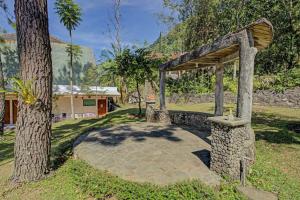 a stone fountain in a yard next to a tree at Hotel O Villa Inn App Trawas Bintaro Syariah in Kemloko-gede