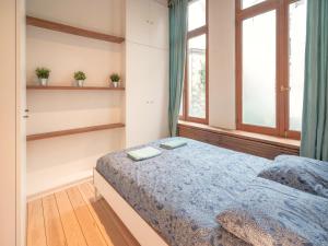 a bedroom with a bed and a window at Stylish Duplex for 6 in Antwerp in Antwerp