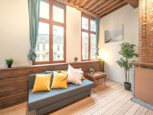 a living room with a couch and windows at Stylish Duplex for 6 in Antwerp in Antwerp