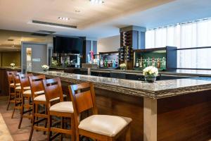 a bar with a bunch of chairs at a bar at Allure Hotel & Conference Center in Barrie