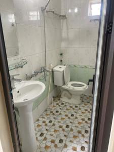 a bathroom with a toilet and a sink at Sơn Tùng House in Quang Ninh