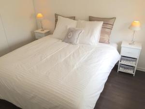 1 dormitorio con 1 cama blanca y 2 mesitas de noche en Appartement Copenhague Disneyland en Montévrain