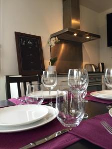 a table with wine glasses on a purple table cloth at Appartement Copenhague Disneyland in Montévrain