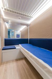 a hospital room with a large blue bed in it at Resting Pods - -ZZZleepandGo MXP Airport in Ferno