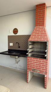 a brick oven in a kitchen with a sink at Casa espaçosa com 3 quartos climatizados in Petrolina