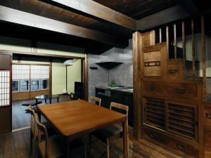 a kitchen and dining room with a wooden table and chairs at Obama Machiya Stay in Obama