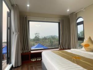 a bedroom with a bed and a large window at Châu Anh House in Ðố Sơn