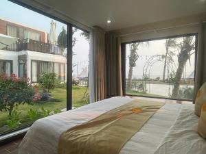 a bed in a room with a large window at Châu Anh House in Ðố Sơn