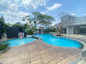 a swimming pool in a courtyard with a building at Moses Homestay, Yogyakarta in Beran-kidul