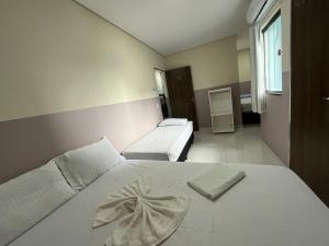 a bedroom with a white bed with a bow on it at Center Prime Hotel in Bom Jesus da Lapa