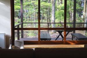 a living room with a couch and a table outside a window at The Cabin by Deep Gorge in Kita-karuizawa