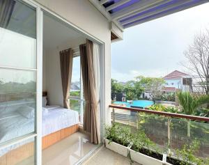 a balcony with a bed and a view of a pool at Moses Homestay, Yogyakarta in Beran-kidul