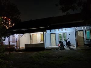 two motorcycles parked outside of a house at night at Bale Sasak guest house in Selaparang +3 photos