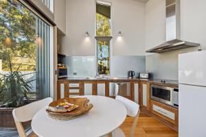 a kitchen with a white table and chairs at Bushland in Halls Gap