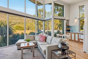 a living room with a couch and large windows at Bushland in Halls Gap