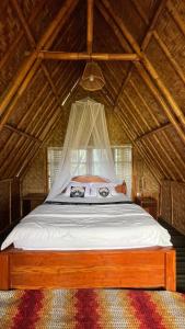 a bed with a mosquito net in a room at Girang Rinjani Bungalows in Tetebatu