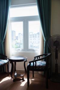 a room with a table and a chair and a window at Royal Dalat Hotel in Da Lat