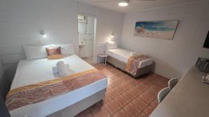 a hotel room with two beds and a bathroom at Sunburst Motel in Gold Coast