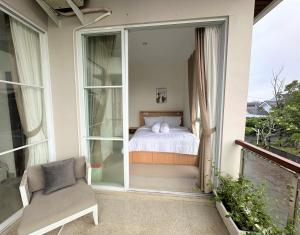 a room with a bed and a chair on a balcony at Moses Homestay, Yogyakarta in Beran-kidul +34 photos