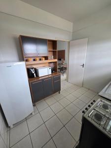 a kitchen with a stove and a refrigerator at Apto Confortável com Ar e Cozinha Equipada in Balsas