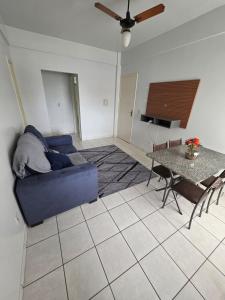 a living room with a blue couch and a table at Apto Confortável com Ar e Cozinha Equipada in Balsas