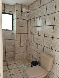 a bathroom with a toilet and a shower at Apto Confortável com Ar e Cozinha Equipada in Balsas
