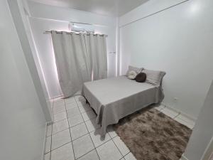 a bedroom with a bed with a pillow and a curtain at Apto Confortável com Ar e Cozinha Equipada in Balsas