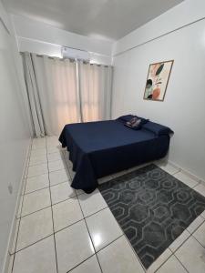 a bedroom with a blue bed and a carpet at Apto Confortável com Ar e Cozinha Equipada in Balsas