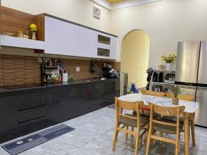 a kitchen with a table and chairs and a refrigerator at Nhật Lệ Oyster House in Dong Hoi