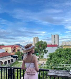 a woman in a hat standing on a balcony at Nhật Lệ Oyster House in Dong Hoi +27 photos