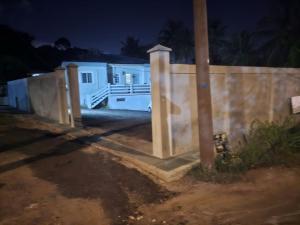 a fence in front of a house at night at Paradies Caraibes IV in Les Abymes