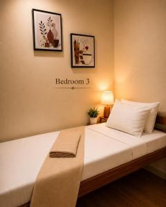 a bed in a room with two pictures on the wall at Davao City Stay at Camella Northpoint Spacious 3BR Condo 5Beds Up to 10 Guests in Davao City