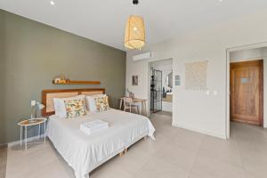 a bedroom with a large white bed in a room at Villa Anosia Laman i Tera in Westpunt