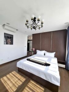 a bedroom with a large bed and a chandelier at Army Hotel in Yen