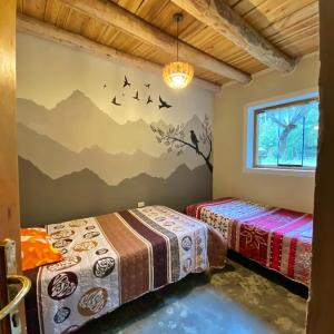 two beds in a room with mountains on the wall at Yanamanka in Yanama