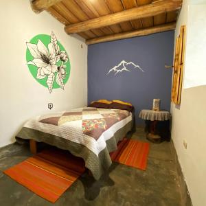a bedroom with a bed with a painting on the wall at Yanamanka in Yanama +10 photos