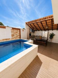 a swimming pool in a patio with a table at Bahia Bela - Casa Duplex 02 in Santa Cruz Cabrália