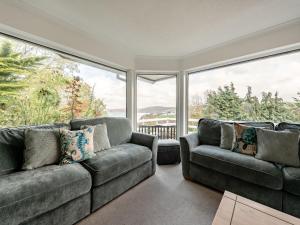 a living room with two couches and a large window at Five Bays View in Aberporth