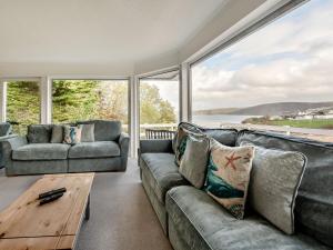 a living room with a couch and a table at Five Bays View in Aberporth