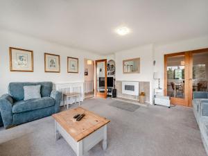 a living room with a blue couch and a table at Five Bays View in Aberporth