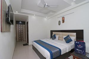 a bedroom with a bed and a flat screen tv at Super Hotel O Sweet Palace in New Delhi