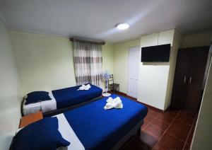 a bedroom with two beds with towels on them at Hostal San Lorenzo in Iquique