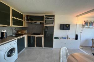 a kitchen with a washer and dryer in a room at Le Studio de la Lagune studio cabine proche de la plage in Le Grau-du-Roi